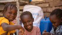 Altuma, a 45-year-old mother of nine, has her children playing together inside their shelter. Displaced from their home in Khartoum by the conflict, her family has had to move several times, and is currently living in an old building without a roof over its head.