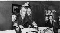 People wave from a train window