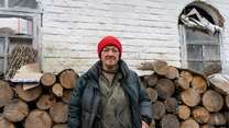 Woman standing in front of fuel logs wearing winter clothes