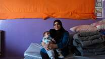 Warda poses for a photo while holding her young son, Mohammad.