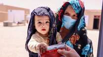 A packet of ready-to-use therapeutic food (RUTF) is given to Sahil and his mother Afsana at the IRC’s EU-supported health facility, during their follow up appointment.