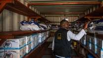 An IRC day laborer stocks IPC kits for the Ebola/Bundibugyo virus response in Centenaire, Bunia, DRC. 