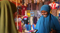 A woman buys fabric in a shop