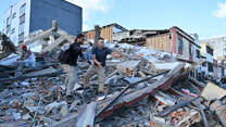 People and rescuers search for victims amid debris of a collapsed building at the city center after a magnitude 7.4 earthquake struck Colombia. 