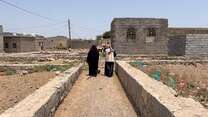 Basma walks with an IRC staff member 