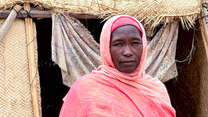 Hawa (45), poses for a photograph outside her shelter.