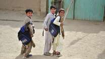 Three boys walk through a school yard in Pakistan.