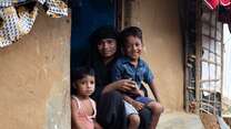 A mother sitting with her two sons on a stoop