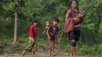 A woman and her children walk to receive vaccinations and medicines from the health team. 