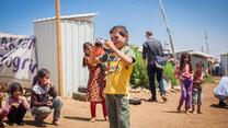 Maher, a Syrian boy, takes photographs of his friends in a refugee camp in Lebanon