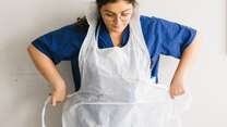 Anxhela Gradeci tying on an apron
