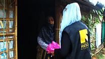 An IRC community volunteer—a refugee from Myanmar who fled to Bangladesh—visits a woman in Cox’s Bazar refugee camp with information about COVID-19 and how to prevent its spread.