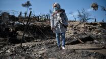 Rahima standing in the burned down Moria camp on the island of Lesvos