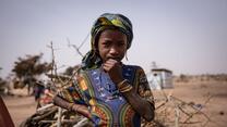 A young girl poses for a portrait in camp for internally displaced people in Barsalogho, Burkina Faso