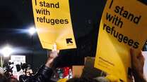 Stand with refugees signs during a protest