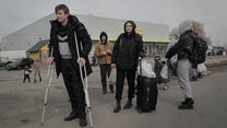 A family flee Ukraine with a young man using crutches 