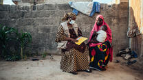 Two women sat next to each other with a young child on the woman lap