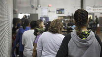 Women and children wait in line to be processed at a U.S. Border Patrol facility in Texas