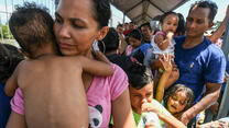 A Honduran migrant couple and their five kids taking part in a caravan heading to the US, wait to cross the border from Ciudad Tecun Uman in Guatemala, to Ciudad Hidalgo, Mexico. Photo: ORLANDO SIERRA/AFP/Getty Images