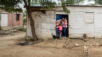 Andrea and her daughters, ages 1 and 9, at the door of the small house their family shares with five other people in Cucuta, Colombia