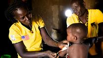 A baby is held by a woman at a health facility in South Sudan
