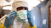 A health worker in the Democratic Republic of Congo puts on his protective mask to care for potential Ebola patients