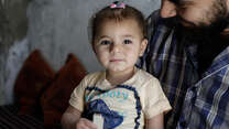 A 32-year-old man holds his 1 1/2 year-old daughter in Armanaz town in western Idlib. 