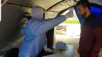A health worker takes a patient’s temperature before they enter a clinic run by the IRC in a town in northwest Syria.