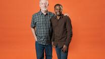 Robert Sebatware and Dave Kurz posing for the camera in front of an orange background. 
