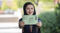 Muska Haseeb holds out her mail-in ballot 