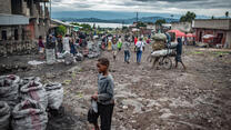 A young boy and other people on the street in Goma, DRC on a cloudy day