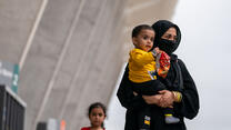 An Afghan woman holds her son as they arrive in the U.S.