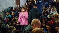 A girl wearing a hoodies is among people sheltering inside a subway station in Ukraine as Russian attacks continue