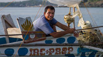A Filipino fisherman sits in his boat on the water.