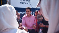 David Miliband in red shirt talking to a crowd