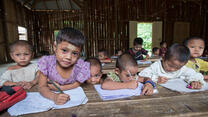 Refugee children hold pencils in a classroom at a refugee camp in northern Thailand