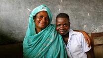 a woman and boy smile at the camera