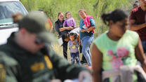 Central American asylum seekers wait as a U.S. Border Patrol agents take groups of them into custody on June 12, 2018 near McAllen, Texas. photo by John Moore/Getty Images