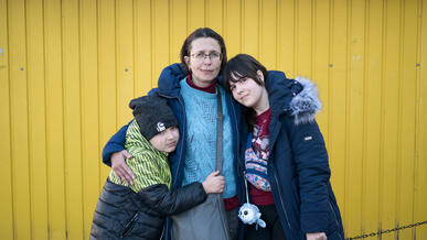 A mother and her two children pose for a photo in Poland after fleeing the war in Ukraine.