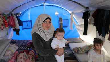 A mother holds her child at a shelter in Syria.