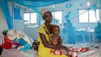 A mother holds her child in a malnutrition clinic.