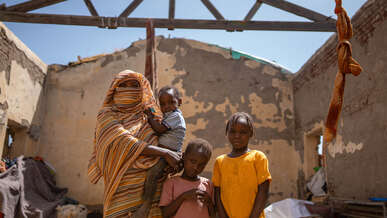 Eine sudanesische Familie posiert für ein Foto in den Ruinen eines durch den Konflikt zerstörten Gebäudes.