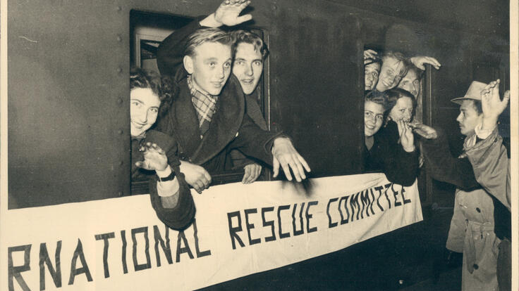 People waving out of a train