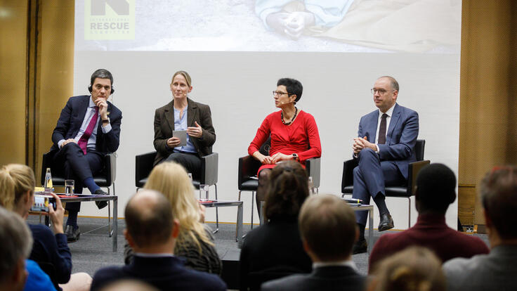 Die Panelisten David Miliband, Julia Steets, Ursula Müller und Niels Annen diskutieren die humanitären Prinzipien im Kreuzfeuer