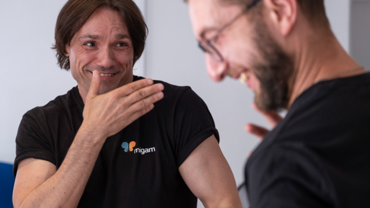 Two men laugh while using sign language