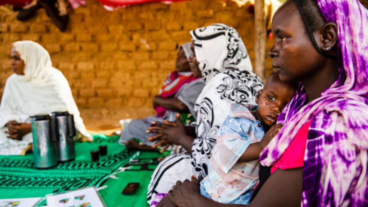 A mother holds her child close in her arms.