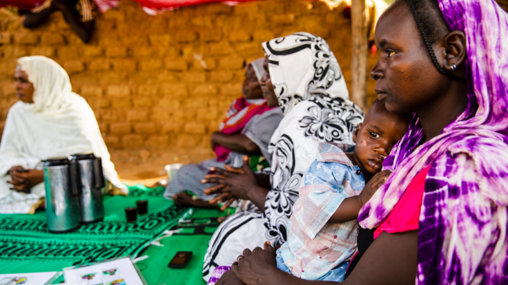 A mother holds her child close in her arms. 