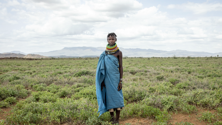 A portrait of a woman dressed in all blue. She looks into the camera.