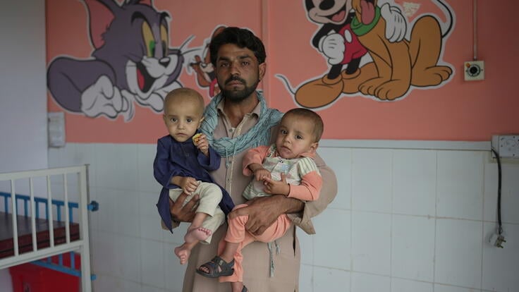 Shakeel, a father of twins Afnan and Adnan, stands in the children's pediatric room while holding the twins