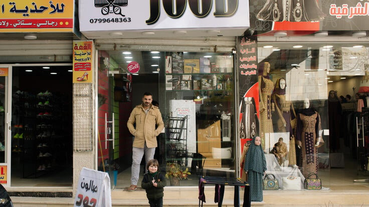 Tarek and his son Jood stand outside their family's salon.